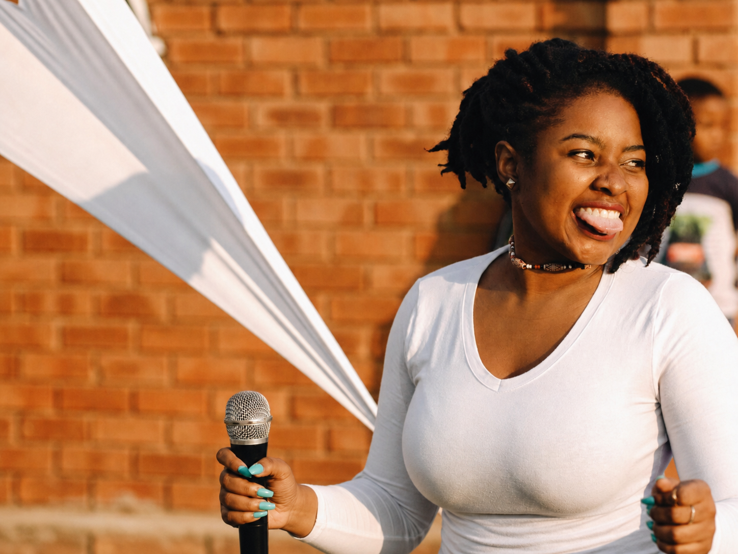 Millicent smiling and holding a microphone